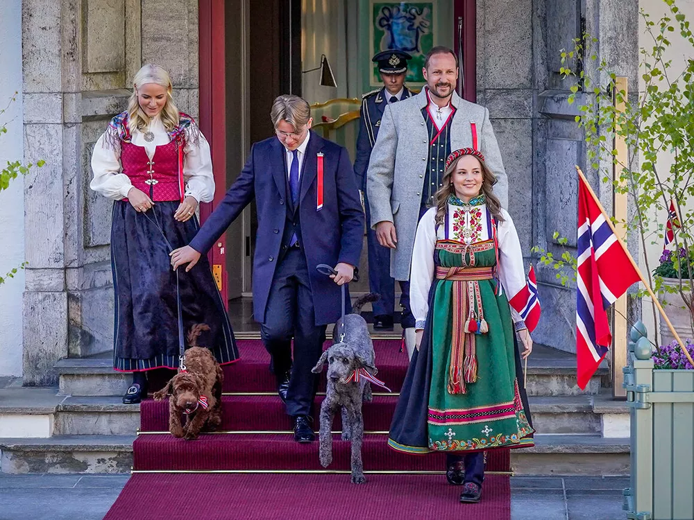 Кронпринцесса Метте-Марит, принц Сверре Магнус, кронпринц Хокон и принцесса Ингрид Александра в национальных костюмах приветствуют праздничное шествие школьников в День Конституции Норвегии 17 мая.
