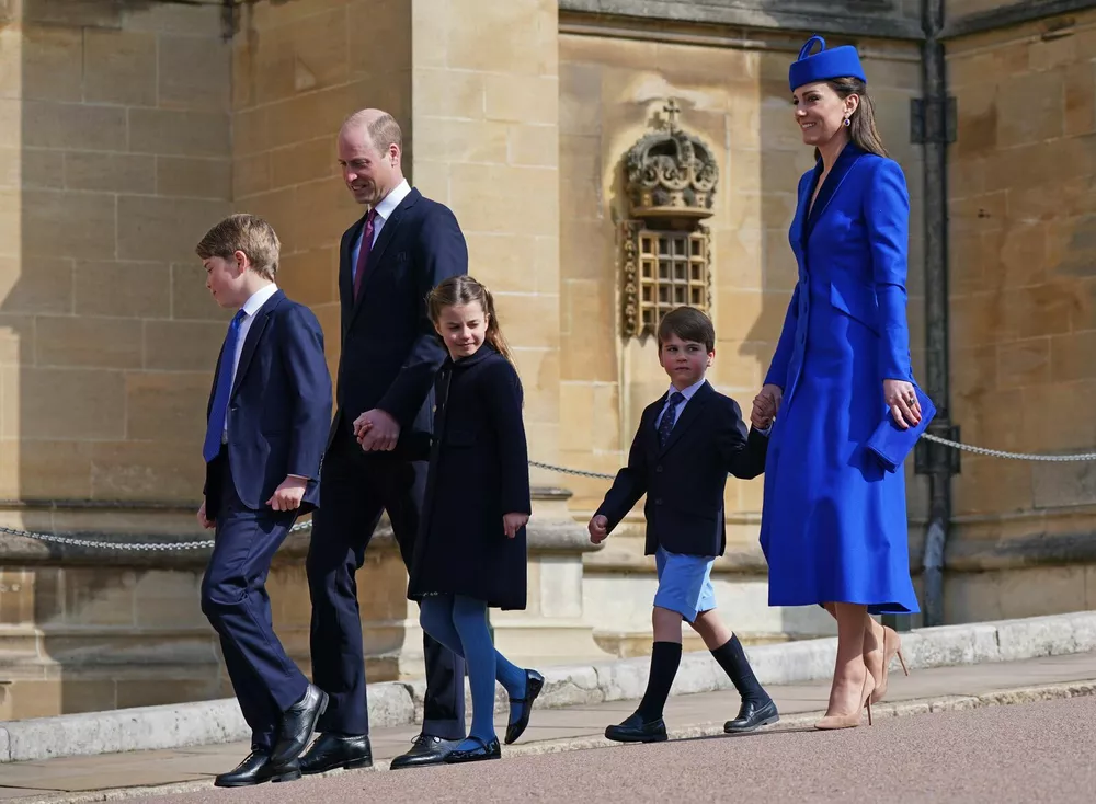 Принц и принцесса Уэльские с детьми в Виндзоре по дороге на пасхальную службу 9 апреля 2023 года. 9-летний принц Джордж уже в брюках, а 4-летний принц Луи - в шортах. Принцесса Шарлотта, как и ее мама, - в колготках. Ногти супруги наследника престола покрыты красным лаком