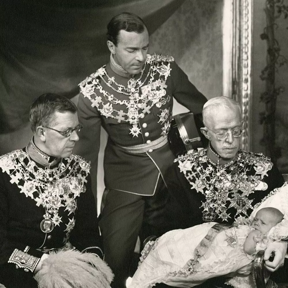 Над младенцем Карлом Густавом склонились (справа налево) его прадед король Густав V, отец Густав Адольф, герцог Вестерботтенский и дед - следующий король Густав VI Адольф