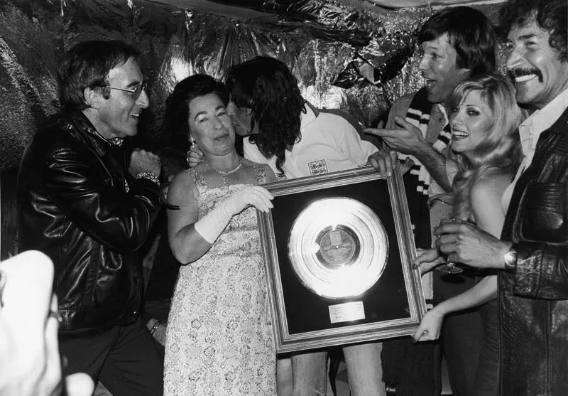 Джанет Чарльз в образе британской королевы вручает группе Alice Cooper музыкальную награду в 1975 году 